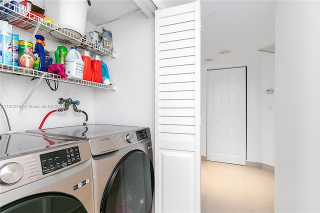 clothes washing area with light tile patterned flooring and washing machine and clothes dryer