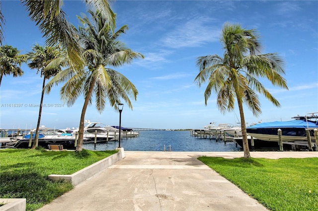 dock area with a water view and a lawn