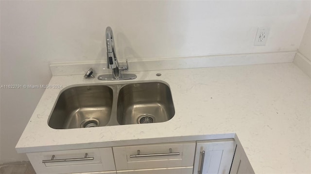 room details featuring light stone counters and sink