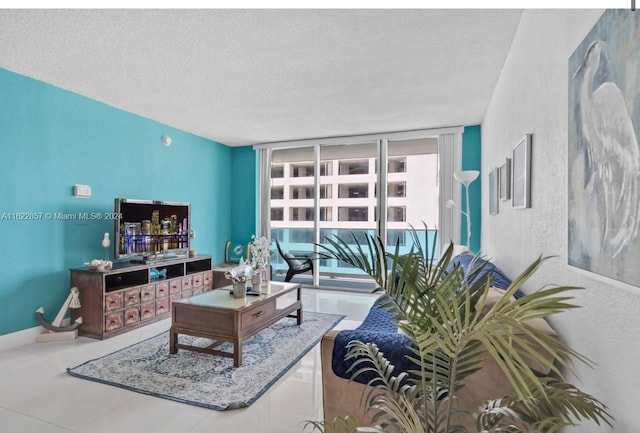 living room featuring a textured ceiling, tile patterned floors, and a wall of windows