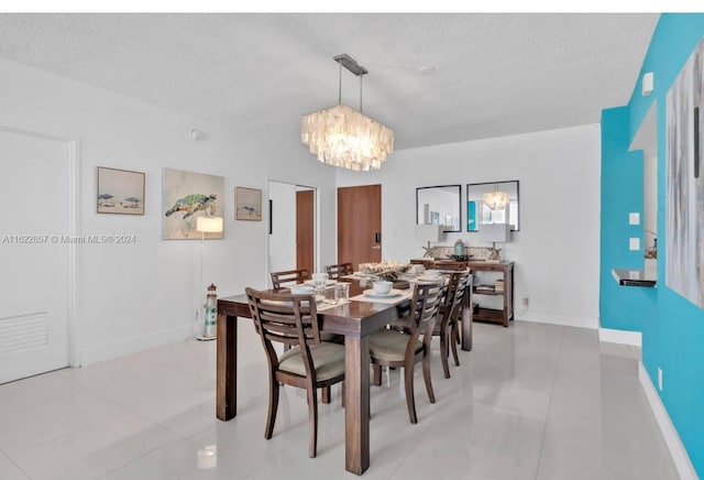 dining space with tile patterned flooring, an inviting chandelier, and a textured ceiling