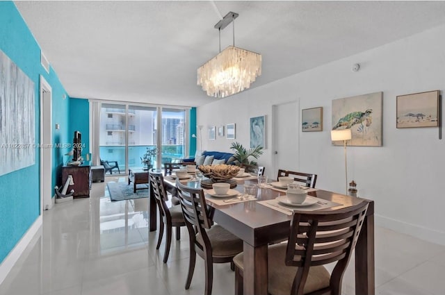 tiled dining area featuring an inviting chandelier, a textured ceiling, and floor to ceiling windows