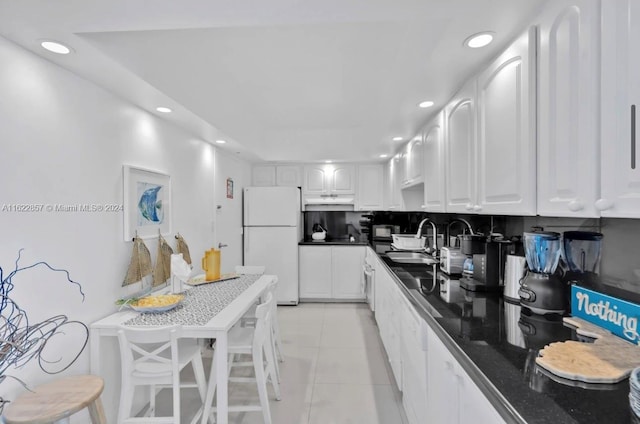 kitchen featuring white cabinetry, light tile patterned floors, a kitchen breakfast bar, white refrigerator, and sink