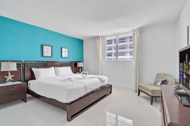 bedroom featuring a textured ceiling and light tile patterned floors