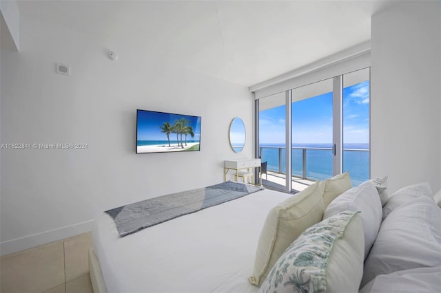 bedroom featuring a water view, access to outside, and light tile patterned flooring