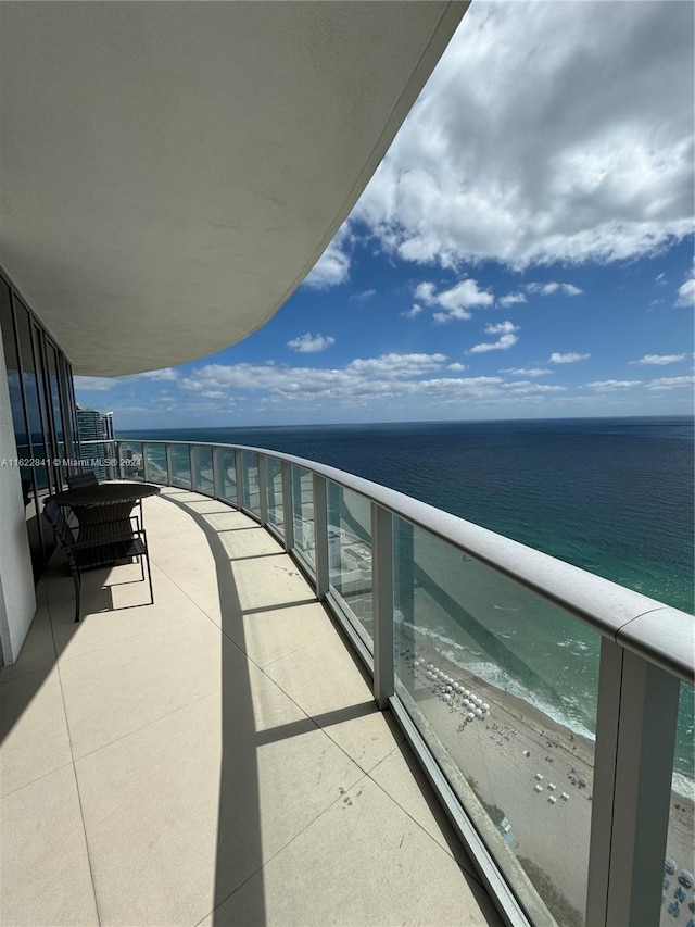 balcony with a water view and a beach view