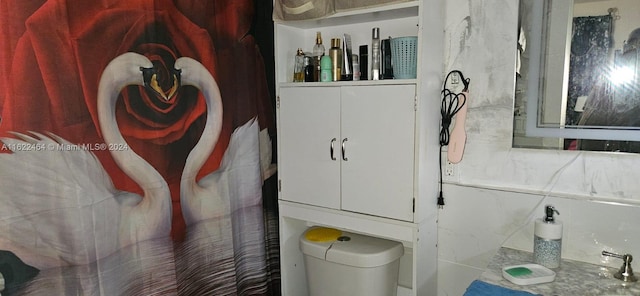 bathroom featuring decorative backsplash, tile walls, and toilet