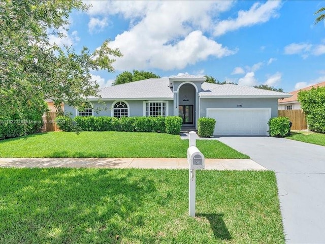 ranch-style house featuring a front yard and a garage