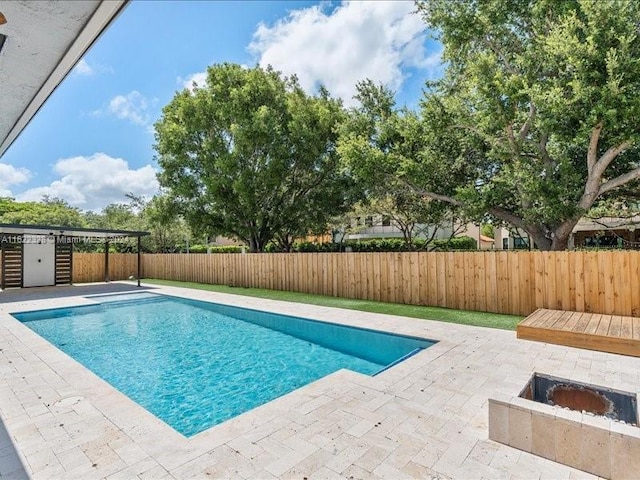 view of swimming pool with a patio area and a fire pit