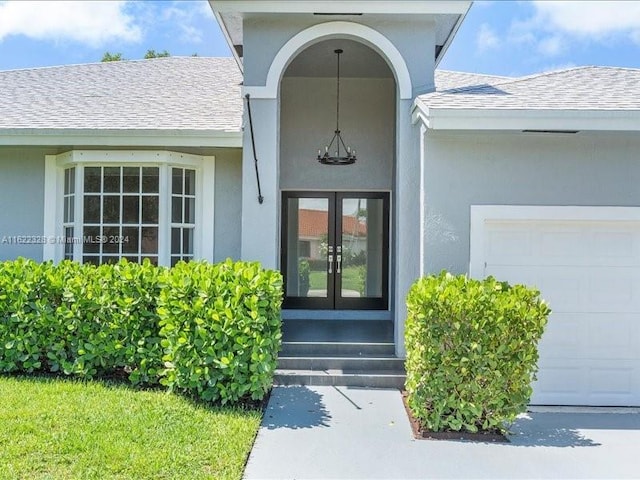 view of exterior entry featuring french doors and a garage