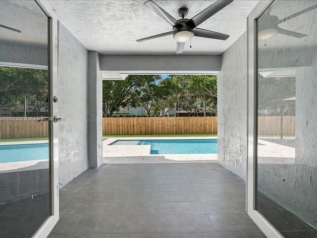 view of pool with ceiling fan and a patio