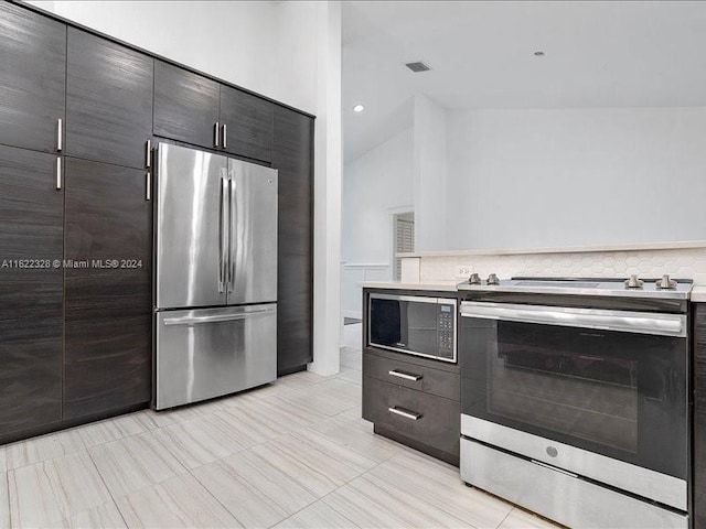 kitchen featuring decorative backsplash, light tile patterned floors, stainless steel appliances, and high vaulted ceiling