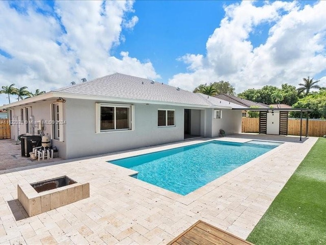 view of pool featuring a fire pit, a shed, and a patio