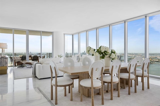 dining space with floor to ceiling windows and a water view