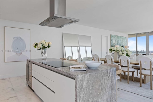 kitchen with island range hood, white cabinetry, a healthy amount of sunlight, and black electric cooktop