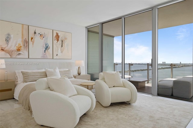 bedroom featuring expansive windows, a water view, access to outside, and multiple windows