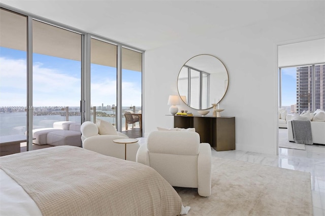 bedroom featuring expansive windows, a water view, and multiple windows