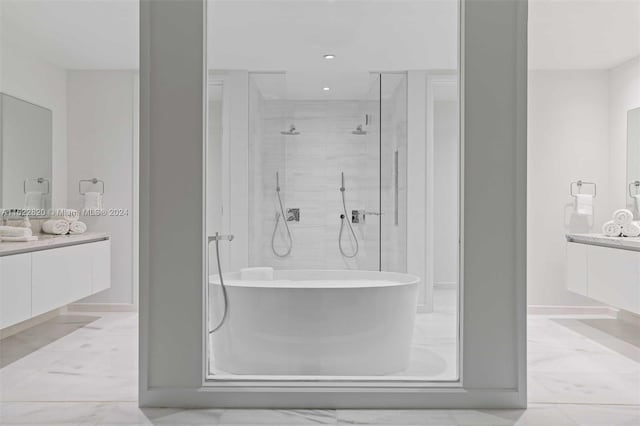 bathroom featuring a shower with door and vanity