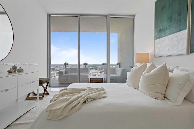 bedroom with floor to ceiling windows and hardwood / wood-style flooring