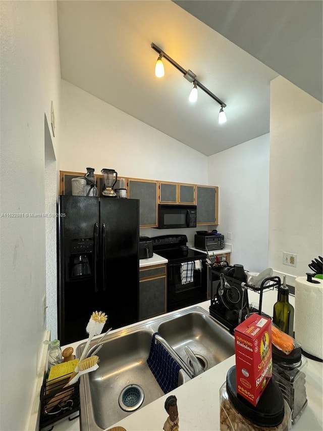 kitchen featuring lofted ceiling, sink, track lighting, and black appliances