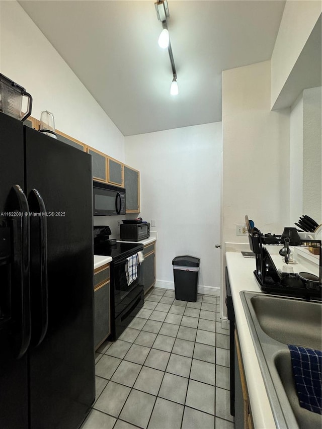 kitchen with light tile patterned flooring, sink, track lighting, and black appliances