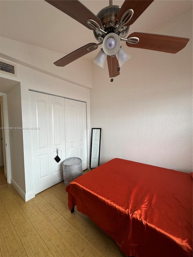 bedroom featuring ceiling fan, light wood-type flooring, and a closet