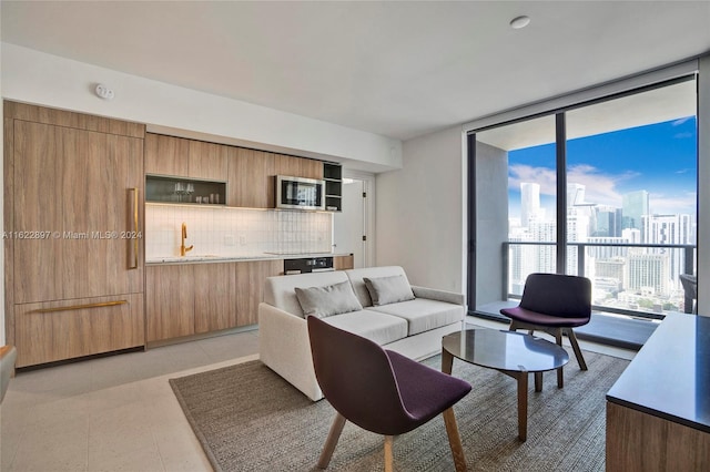 tiled living room with sink and floor to ceiling windows