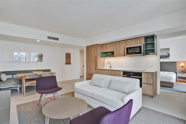 living room featuring light tile patterned flooring and sink