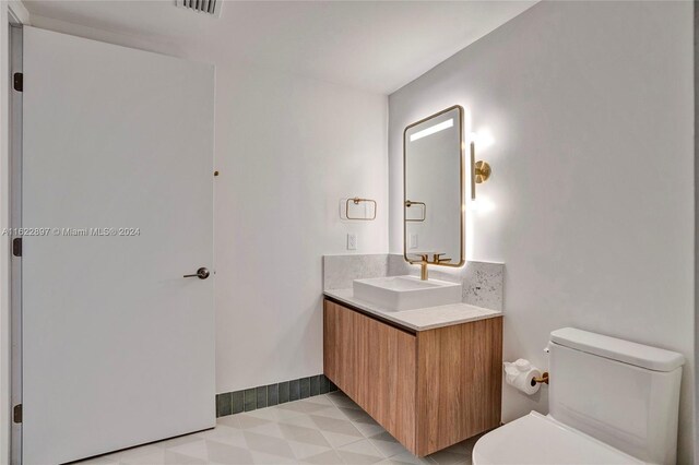 bathroom with tile patterned flooring, toilet, and vanity