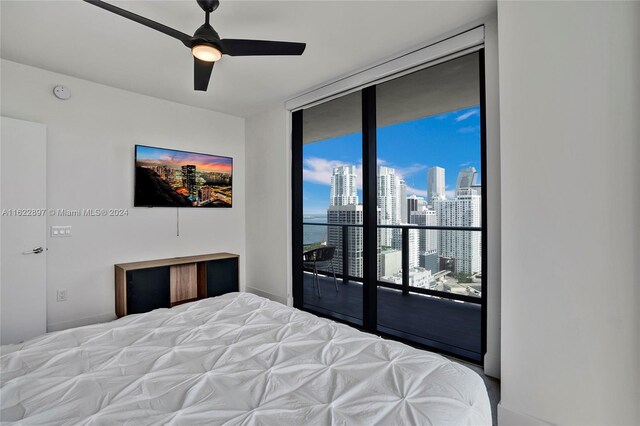 bedroom featuring access to exterior, ceiling fan, and a wall of windows