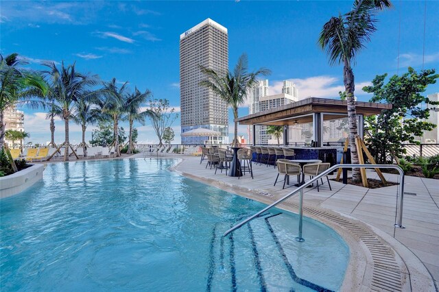 view of swimming pool with a bar and a patio