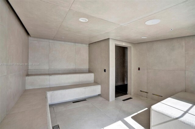 bathroom with tile patterned floors and tile walls