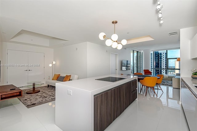 kitchen featuring expansive windows, a raised ceiling, black electric cooktop, dark brown cabinets, and a kitchen island