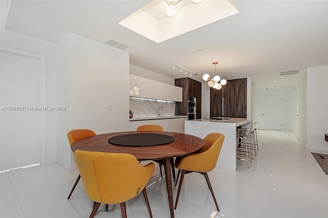 tiled dining room with a notable chandelier