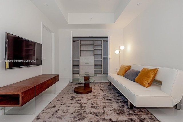 living room featuring tile patterned floors and a tray ceiling