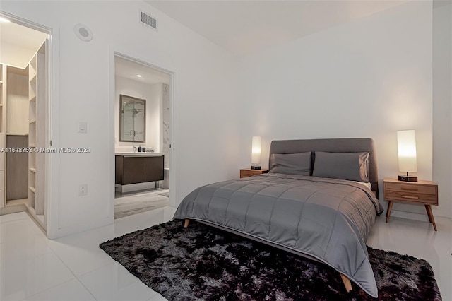 bedroom featuring light tile patterned floors and connected bathroom