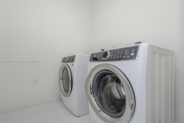 laundry room with washing machine and dryer and light tile patterned floors