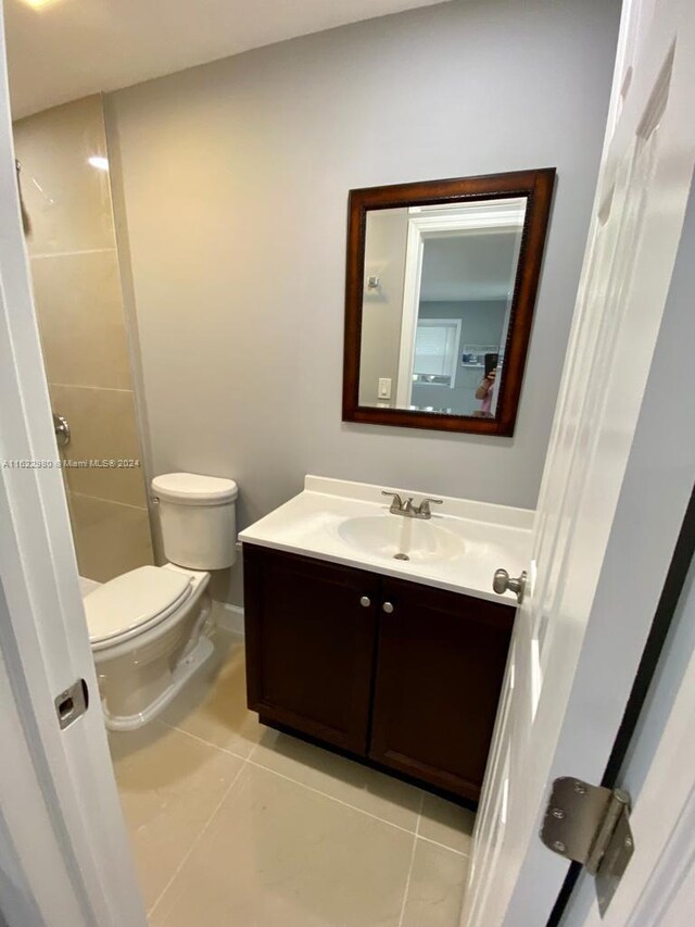 bathroom featuring tile patterned flooring, toilet, and vanity