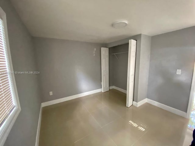 unfurnished bedroom featuring a closet and tile patterned flooring