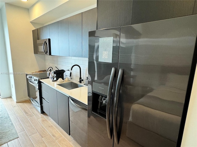 kitchen featuring stainless steel appliances, tasteful backsplash, and sink