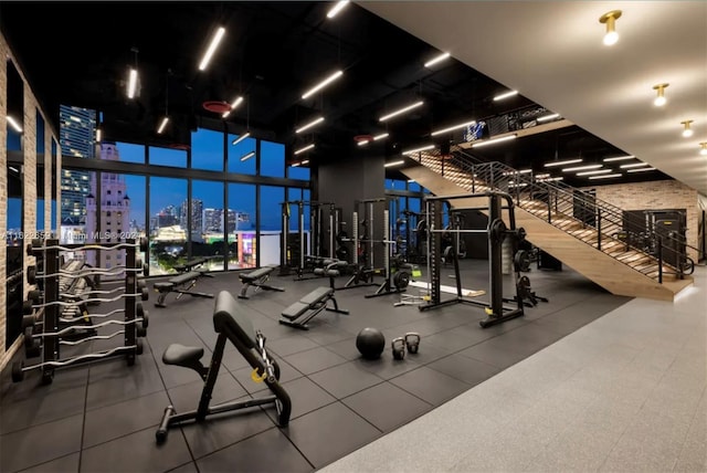 workout area featuring a wall of windows and a towering ceiling