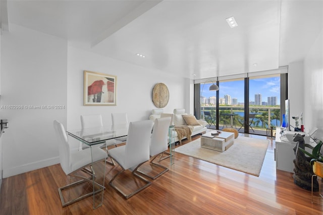 dining area featuring expansive windows, baseboards, and wood finished floors