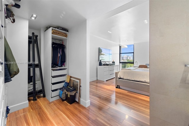 bedroom with light hardwood / wood-style floors and a closet