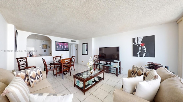 tiled living room featuring a textured ceiling