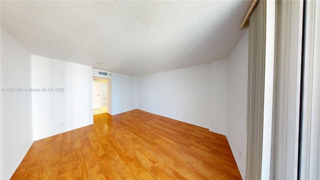 bedroom featuring access to exterior, light wood-type flooring, and a textured ceiling