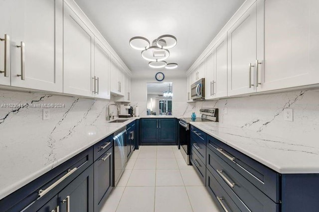 kitchen featuring tasteful backsplash, stainless steel appliances, light tile patterned floors, and white cabinets