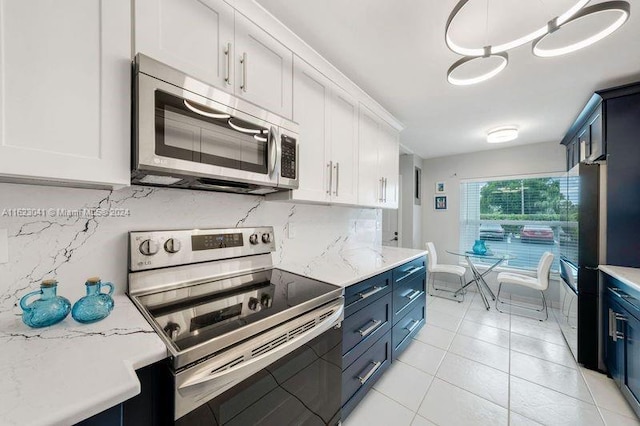 kitchen featuring white cabinets, hanging light fixtures, appliances with stainless steel finishes, and blue cabinets