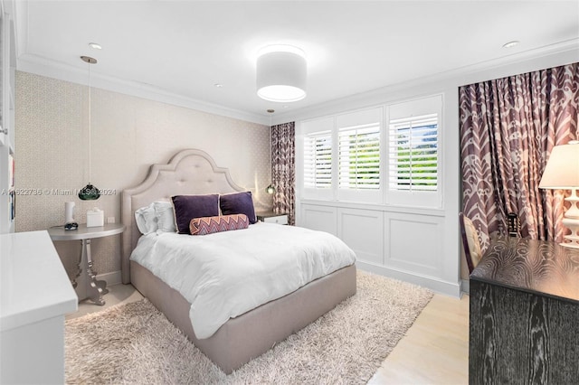 bedroom with light wood-type flooring and crown molding