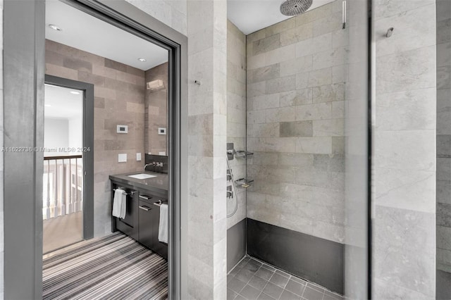 bathroom featuring a tile shower and vanity