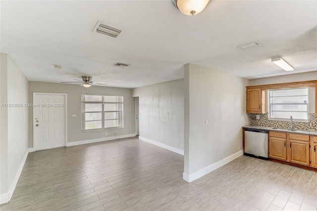 kitchen with stainless steel dishwasher, sink, ceiling fan, and plenty of natural light